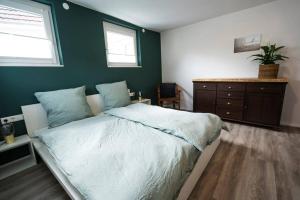 una camera con letto e parete verde di Apartment in Weinstadt-Schnait a Weinstadt