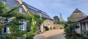 a house with ivy growing on the side of it at La Ferme aux Fleurs in Ossun