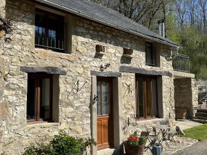 a stone house with a wooden door and windows at Cottage - The Moulin Treillard - Sleeps3 - Parking in Saint-Hilaire-La-Treille