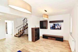 a large living room with a television and stairs at Casa Albert in Iaşi