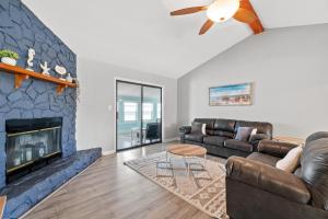 sala de estar con sofá y chimenea en Beach House - Moasis by Panhandle Getaways, en Panama City Beach