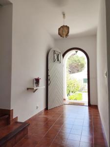 a hallway with an arched door and a tile floor at S'AUBA villa exclusiva con piscina privada de agua salada y horno de pizza in Es Mercadal