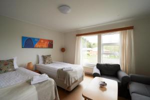 Zimmer mit 2 Betten, einem Sofa und einem Fenster in der Unterkunft Solheimar Eco-Village Guesthouse in Sólheimar
