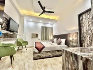 ein Hotelzimmer mit einem Bett und einem TV in der Unterkunft Hotel Cosmo - Karol Bagh in Neu-Delhi
