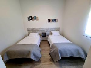 2 camas en una habitación pequeña con ventana en Azulrelax Hostel, en Pinhal Novo