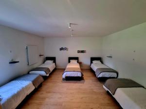 a row of beds in a room with wooden floors at Azulrelax Hostel in Pinhal Novo
