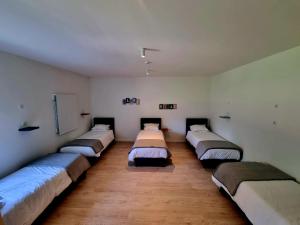 fila de camas en una habitación con suelo de madera en Azulrelax Hostel, en Pinhal Novo
