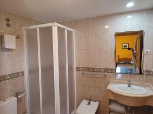 Un baño con lavabo, inodoro y espejo. en Apartamentos Casa Modesto, en Escalona 37 fotos más