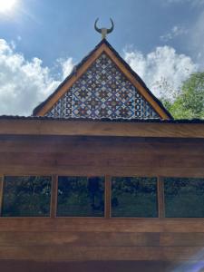 um edifício com telhado de azulejo e janelas em Para para cafe & cottage em Berastagi