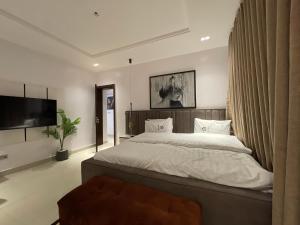 a bedroom with a large bed and a flat screen tv at Magnificent 3-Bedroom in VI in Lagos