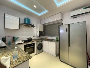 a kitchen with a stainless steel refrigerator and a dishwasher at Magnificent 3-Bedroom in VI in Lagos