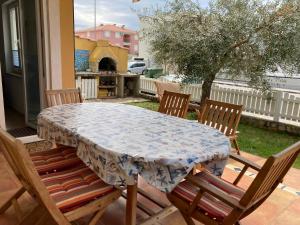 a table with chairs and a table cloth on a patio at App Oljka in Karigador