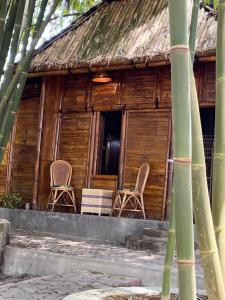 two chairs sitting on the porch of a house at Para para cafe & cottage in Berastagi