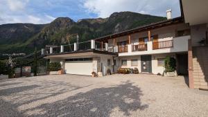 a large building with a garage and mountains in the background at Jägerheim in Vilpiano
