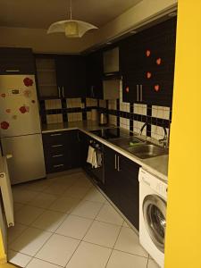 a kitchen with a sink and a washing machine at Apartament do wynajęcia in Olecko