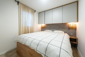 um quarto com uma grande cama branca e armários brancos em Tiny home Rubi in Oaza Mira resort em Drage