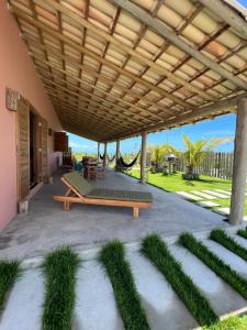 a patio with a bench under a wooden pergola at Villa Savoia Corumbau in Corumbau