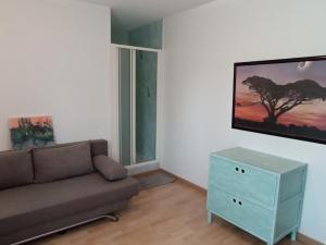 sala de estar con sofá y TV en la pared en La tranquilité, en Saint-Cézaire-sur-Siagne