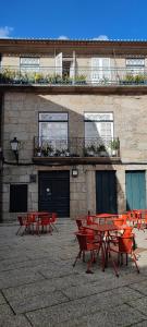 a group of red picnic tables in front of a building at Alojamento Local F&B in Guimarães