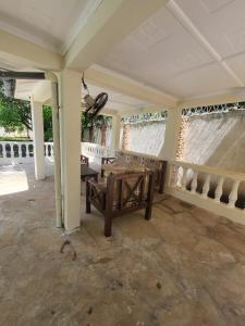 a living room with a table and two windows at LeoMar 2 Diani Beach Ferienhaus mit grossen tropischen Garten und Pool in Ukunda