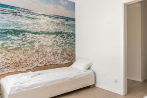 a bedroom with a painting of the ocean at Apartament SŁONECZKO Rezydencja Ustronie Morskie in Ustronie Morskie