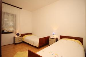 ein Schlafzimmer mit 2 Betten und 2 Lampen an Tischen in der Unterkunft Apartments by the sea Susica, Ugljan - 841 in Ugljan