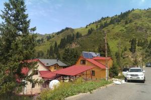 WhiteForShymbulak في Besqaynar: منزل به شاحنة متوقفة أمام جبل