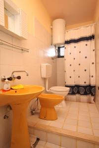 ein Badezimmer mit einem gelben Waschbecken und einem WC in der Unterkunft Apartments by the sea Susica, Ugljan - 841 in Ugljan