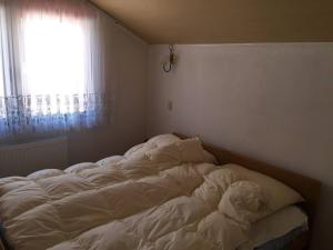 WhiteForShymbulak في Besqaynar: سرير غير مرتب في غرفة نوم مع نافذة