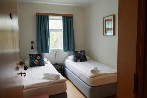 1 dormitorio con 2 camas y ventana en Solheimar Eco-Village Guesthouse, en Sólheimar