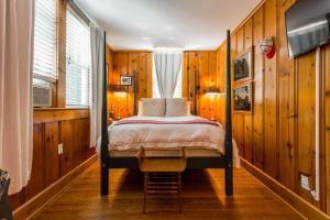 a bedroom with a bed in a room with wooden walls at Leroy Satchel Paige at Southmoreland on the Plaza in Kansas City