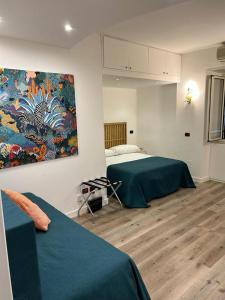 ナポリにあるMH デザイン ホテルのベッドルーム1室(ベッド1台付)が備わります。壁には絵画が飾られています。
