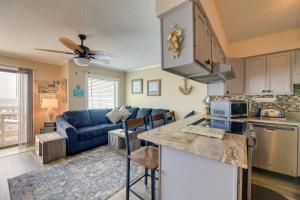 a kitchen and living room with a blue couch at Coastal Condo with Indoor and Outdoor Pool Access in Emerald Isle