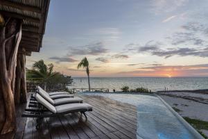 a group of chairs sitting on a deck next to a pool at DK Luxury Ocean Front Villa - Adults Only in Holbox Island