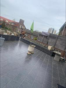 a patio with two benches and a green flag at Private room in the centre of Tilburg in Tilburg