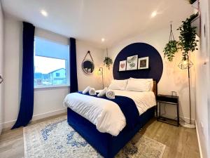 1 dormitorio con 1 cama grande y ventana grande en Luxury Sunrise to Sunset Beachfront Apartment, en Perranporth