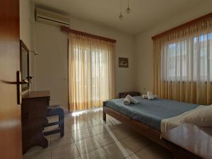 a bedroom with a large bed and a window at Maistreli Hotel Apartments in Stoupa