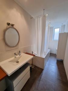 a bathroom with a sink and a mirror and a tub at Süße Marie in Karlsruhe