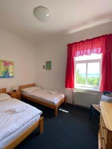 a room with two beds and a window at Hotel pod Šikmou Věží in Jičín