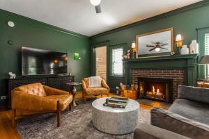 a living room with green walls and a fireplace at Clara and Russell Stover at Southmoreland on the Plaza in Kansas City