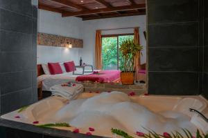 a bath tub in a room with a bedroom at Coffee Lodge Cristal Glamping & Spa in Mindo