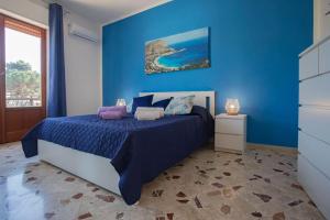 - une chambre bleue avec un lit et un mur bleu dans l'établissement Sea Air - Aria di Mare, à Casteldaccia
