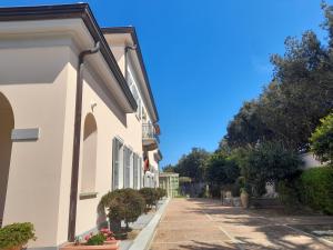 una strada di un edificio bianco con piante e alberi di Villa Ersilia a Soverato Marina