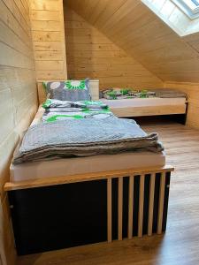 a bedroom with two beds in a wooden cabin at Apartament na poddaszu u Reni in Grywałd