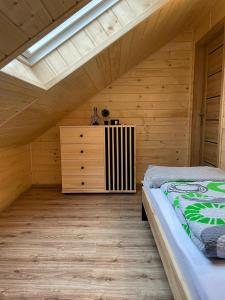 a bedroom with a bed and a dresser in a attic at Apartament na poddaszu u Reni in Grywałd
