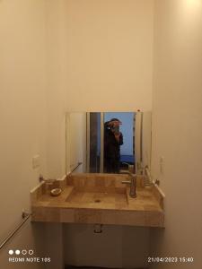 El Breve Espacio في بوبلا: رجل يلتقط صورة لمرآة الحمام