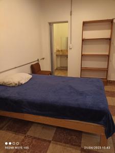 Un dormitorio con una cama con una manta azul. en El Breve Espacio en Puebla