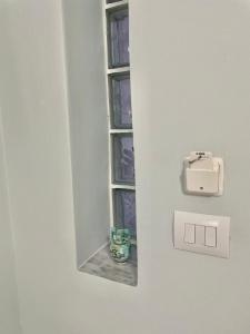a window in a wall with a candle in it at GUGA Host House in Sarandë