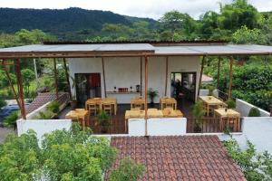 Casa con patio con mesas y sillas en Coffee Lodge Cristal Glamping & Spa, en Mindo