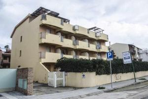 un edificio con una señal de estacionamiento delante de él en Bilocale Fronte Mare Sparaglione en Sassari